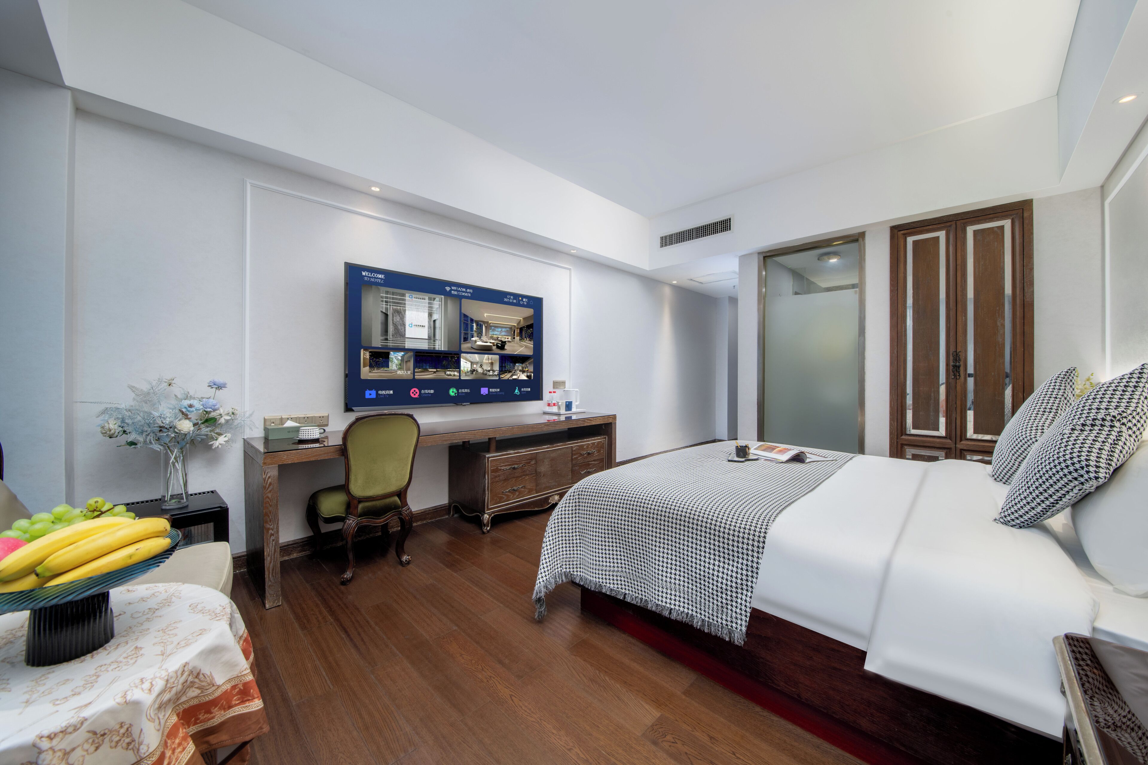 Et moderne hotelværelse med seng, skrivebord og garderobe.