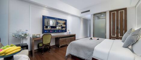Et moderne hotelværelse med seng, skrivebord og garderobe.