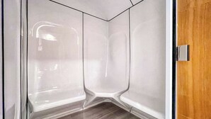 A corner of a room with a wooden floor and a white wall.