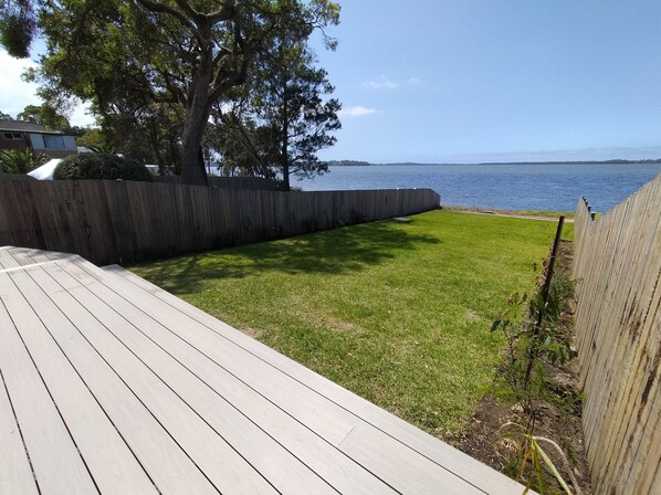 Una terraza con césped y valla de madera.