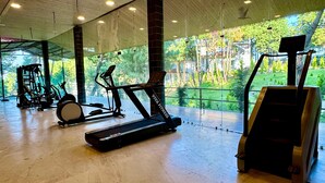 A gym with cardio machines, a treadmill, and a stationary bike. - KUMAON ECO RESORTS (Dwarahat)