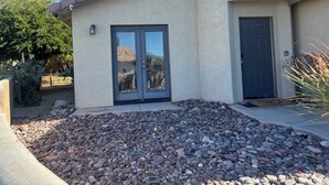 A house with a stone-paved front yard, a double door, and a small window.