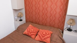 A neatly arranged bedroom with a patterned headboard, a brown quilted bedspread, and two matching pillows. - St Cyprien: An enchanting interlude on the marina (Saint-Cyprien)