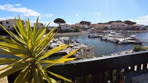A marina with boats docked, a clear sky, and buildings in the background. - St Cyprien: An enchanting interlude on the marina (Saint-Cyprien)