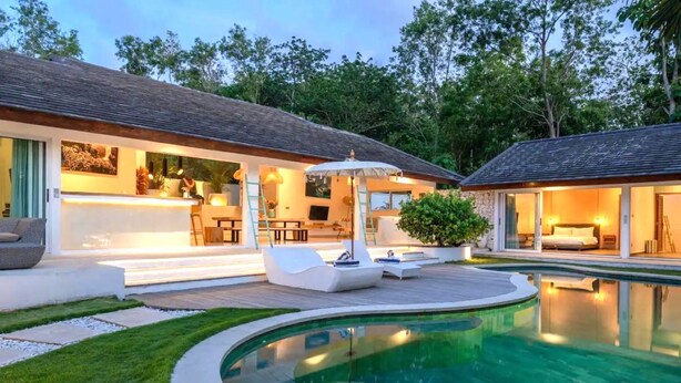 A modern house with a swimming pool, outdoor seating, and a well-lit interior. - Mateo Villa Uluwatu  (Pecatu)