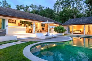 A modern house with a swimming pool, outdoor seating, and a well-lit interior. - Mateo Villa Uluwatu  (Pecatu)
