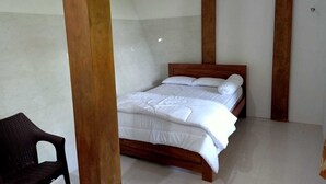Un dormitorio con cama de madera, ropa de cama blanca y una sola silla.