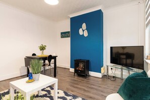 Relax in this stylish living room with a dining table, coffee table, and comfortable sofa.