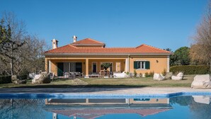 Una casa a due piani con una piscina di fronte.