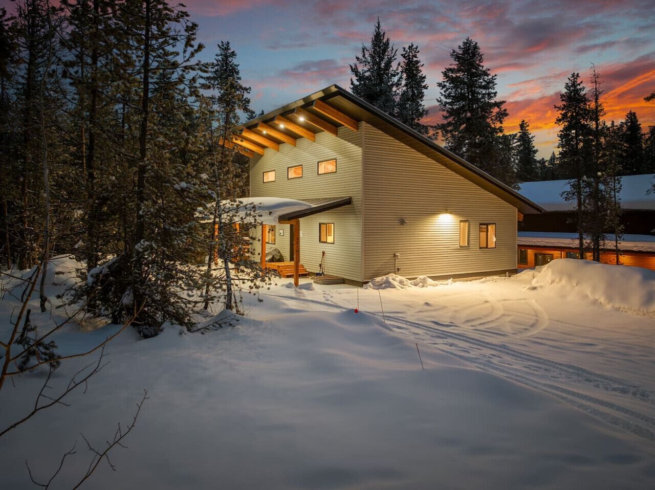 A modern cabin with a sloped roof, wooden beams, and a porch.