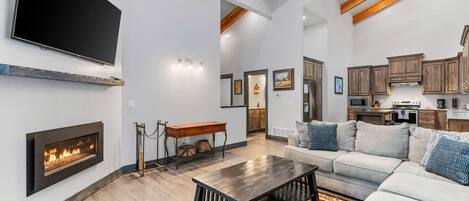 Un salón amplio con chimenea, televisor grande y una zona de estar acogedora.
