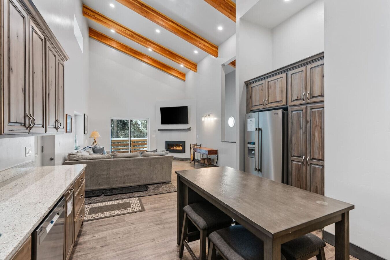 Una cocina moderna con vigas de madera, una isla integrada y un comedor.