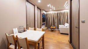 A hotel room with a dining area, a sofa, and a TV. - Pleasant Chiangmai (Chiang Mai)