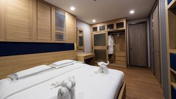 A hotel room with a large bed, wooden wardrobe, and a walk-in closet.