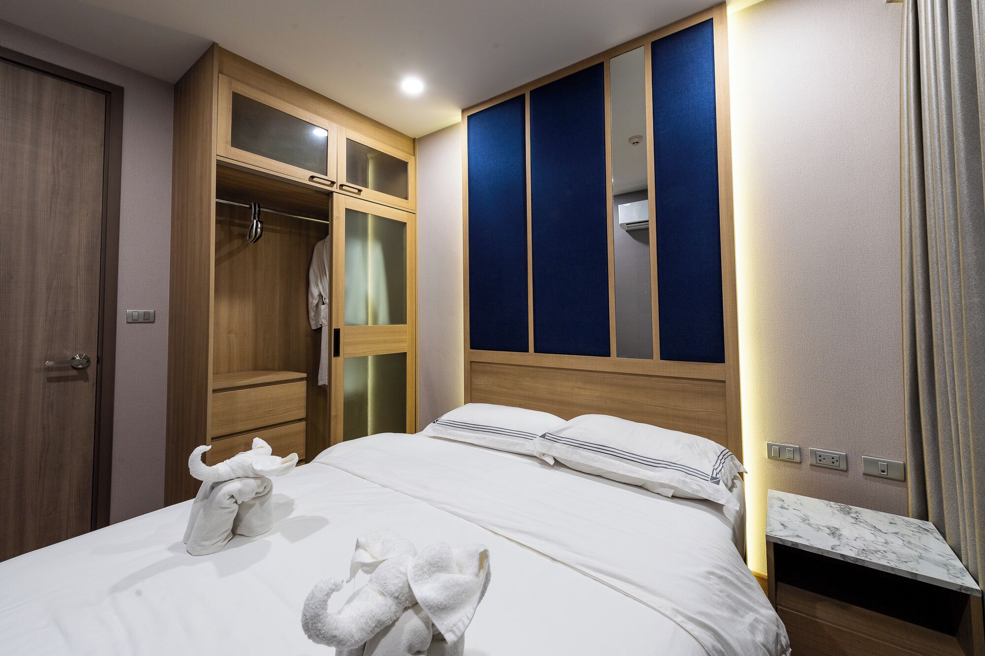 Habitació d'hotel amb un llit, un armari i un mirall.
