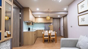 A compact living space with a kitchenette, dining area, and a sofa. - Pleasant Chiangmai (Chiang Mai)