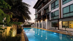 A modern hotel with a swimming pool, surrounded by lush greenery and well-lit outdoor areas. - Pleasant Chiangmai (Chiang Mai)