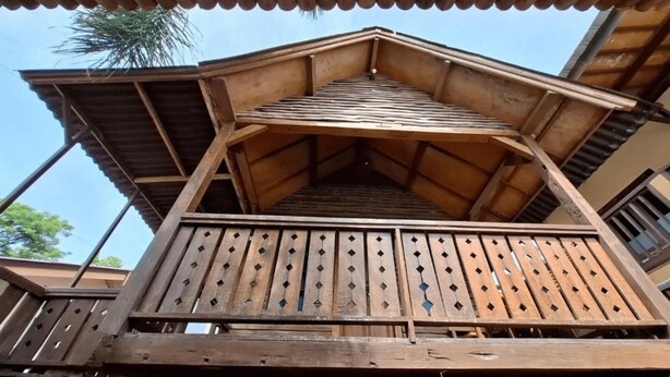 A wooden balcony with a sloped roof and a railing. - Brown Sugar Homestay (Gili Trawangan)