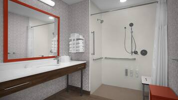 Un baño moderno con un espejo grande, zona de ducha y tocador con toallero.