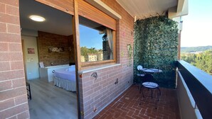 Un balcon avec un mur en briques, une fenêtre et une vue sur la ville.