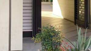 L’entrée d’un hôtel, avec une enseigne indiquant « Perugia Suite B&B », une allée couverte et des plantes en pot.