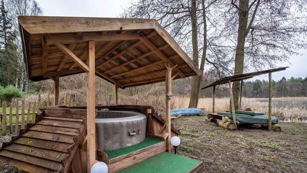 A wooden structure with a hot tub, steps, and a green platform. - Apartment 7 – Nature Retreat at the Resort near Lychen (Lychen)