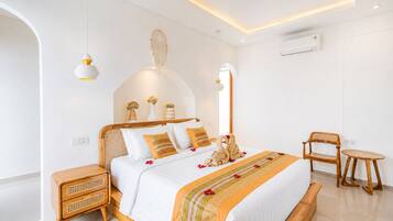 Un dormitorio moderno con cama, mesitas de noche, una silla y una pequeña mesa.