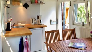 A compact kitchen with a sink, coffee maker, and storage shelves. - Mobile Home 'Traumwagen An Der Mühle' with Private Terrace, Shared Garden and Wi-Fi (Nordermeldorf)