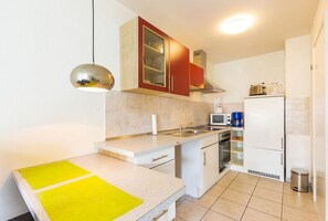 A compact kitchen with a microwave, stove, and refrigerator.