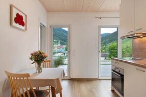 Une cuisine moderne donnant sur un paysage verdoyant, avec une porte vitrée.
