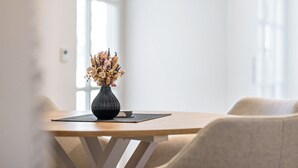 A dining table with a vase of dried flowers, a placemat, and a chair. - Apartment 'Naupenblick' with Private Terrace and Wi-Fi (Albstadt)