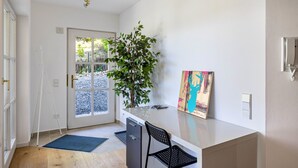 A modern kitchen with a large island, a dining area with a chair, and a door leading to a garden. - Apartment 'Naupenblick' with Private Terrace and Wi-Fi (Albstadt)