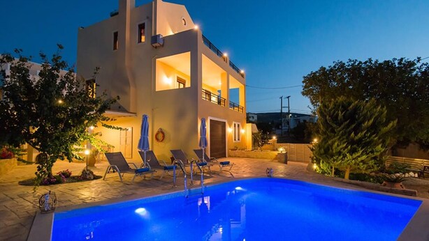 A modern two-story house with a swimming pool, lounge chairs, and a well-lit outdoor area. - Νikolaos Villa with Private Pool, Playground & BBQ (Rethymno)