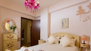 A bedroom with a bed, a dresser, a nightstand, a lamp, and a chandelier. - Νikolaos Villa with Private Pool, Playground & BBQ (Rethymno)