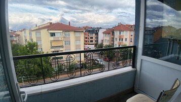 Un balcón con barandilla de metal que da a una zona residencial con edificios de varios pisos.