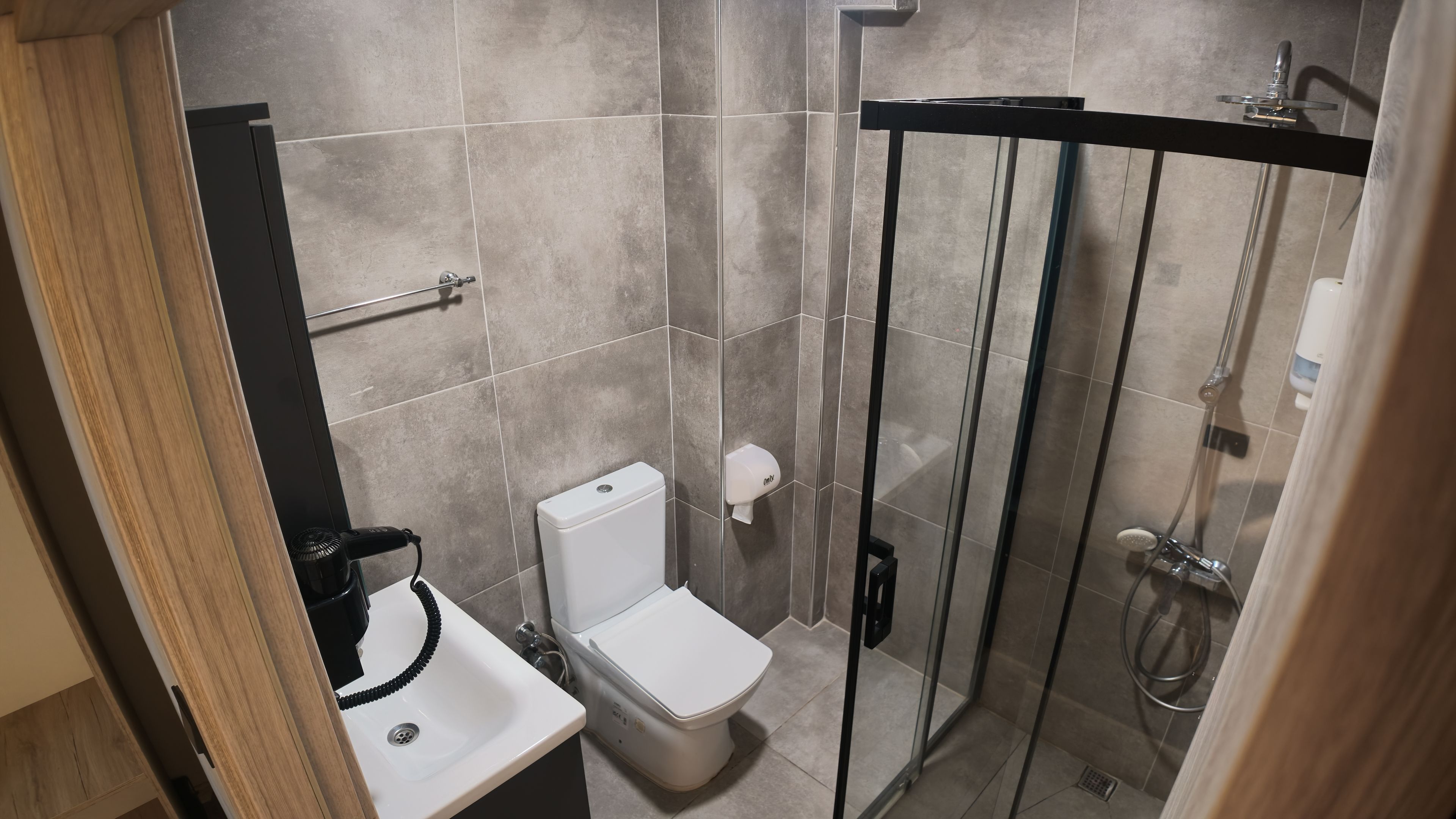 A modern bathroom with a toilet, sink, and glass-enclosed shower.