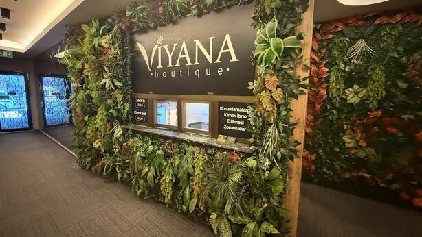 A boutique hotel reception area with a wall decorated with various plants and a sign reading "VIVANA Boutique". - Viyana Boutique Otel (Kutahya)