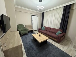 Quarto casal luxo, sacada, vista para a cidade | Área de estar | TV LED 82 polegadas com canais via satélite