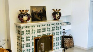 Una sala de estar con chimenea, un sofá, una mesa de comedor y una escalera.