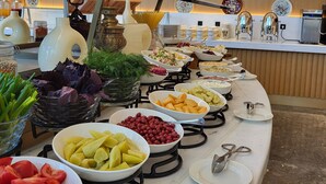 A buffet with various food items and a coffee machine.