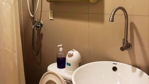 Une salle de bain comprenant des toilettes, un lavabo, une douche et un meuble à miroir.
