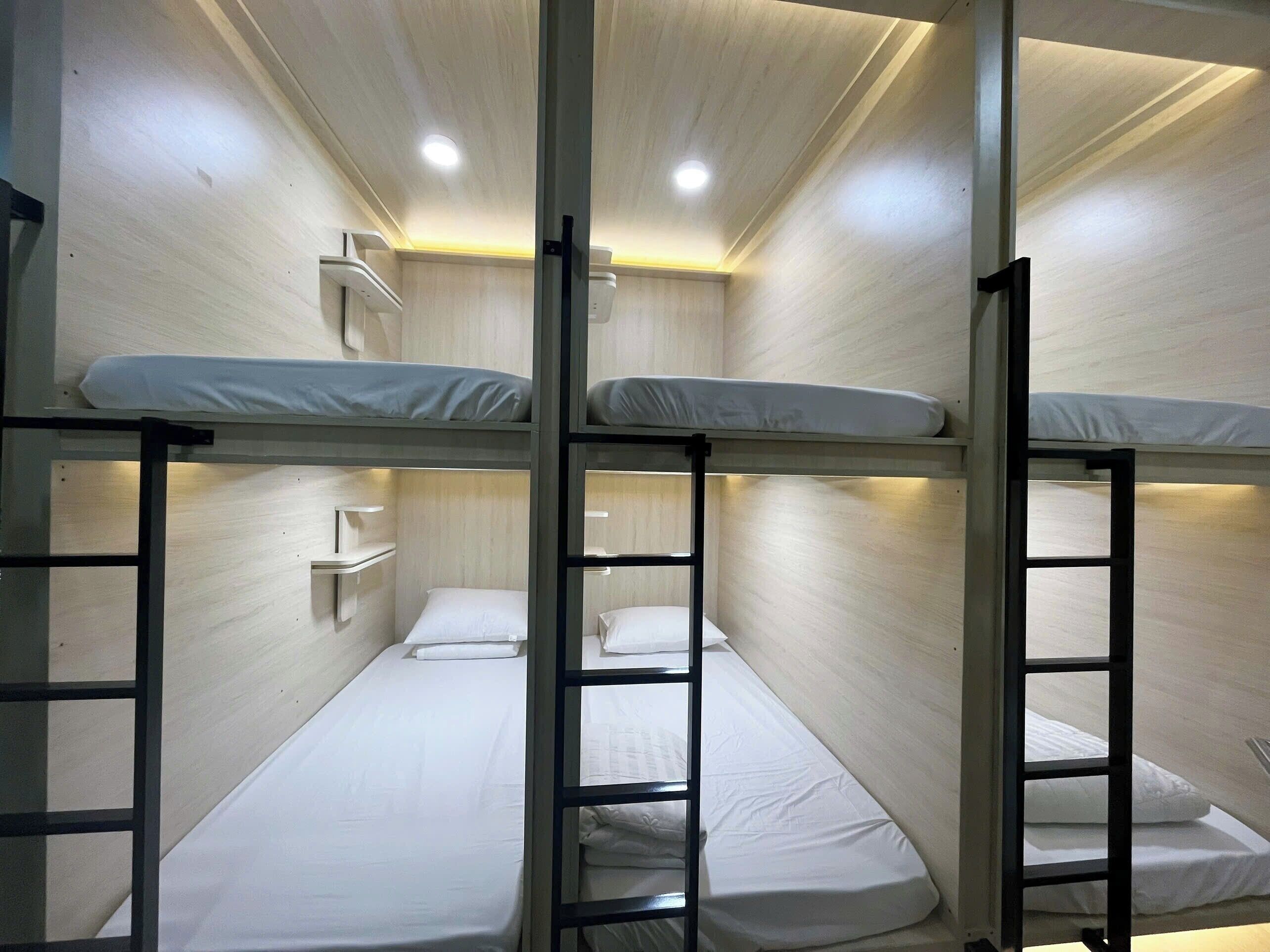 Quarto com beliche, parede de madeira, prateleira e escada.