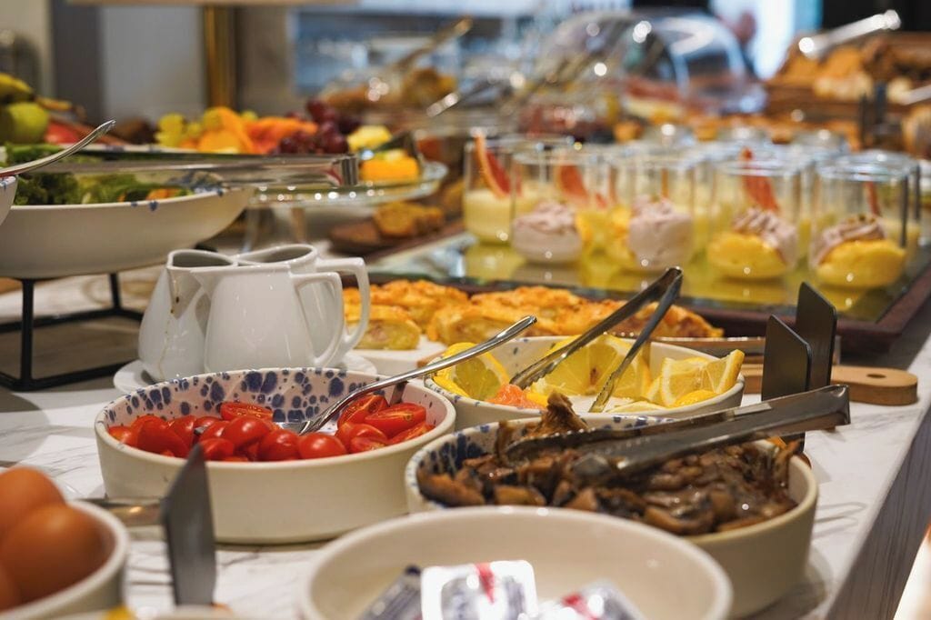A buffet with various food items including fruits, vegetables, and prepared dishes.