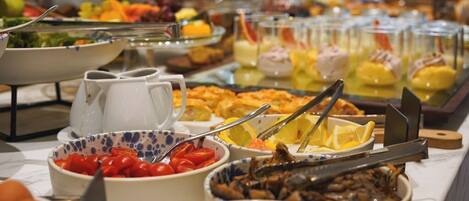 Un buffet proposant une variété d’aliments, notamment des fruits, des légumes et des plats préparés.