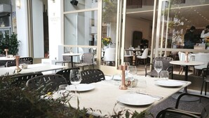 An indoor dining area with tables set for two, large windows, and a sign reading "ETERNITY". - Eternity Athens (Athens)