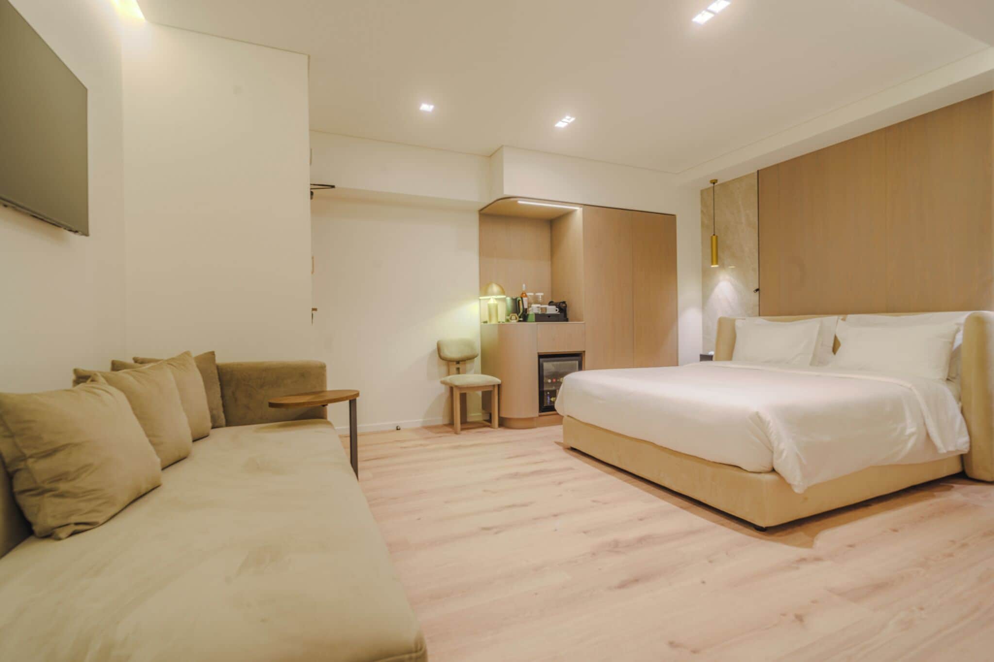 Une chambre moderne avec un grand lit, un canapé et une petite table.