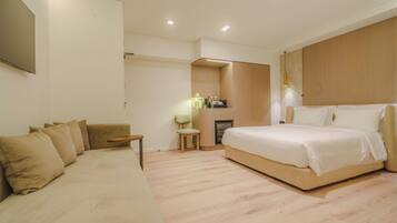 Une chambre moderne avec un grand lit, un canapé et une petite table.
