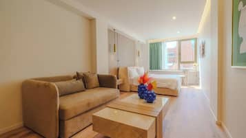 Una sala moderna con sofá, mesa de centro y cama con vistas.