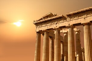 Αρχαίοι ελληνικοί κίονες με φόντο ένα ηλιοβασίλεμα.