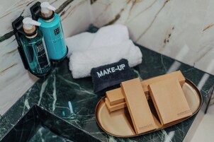 Un baño con encimera de mármol, una toalla blanca y dos botellas de jabón para manos.